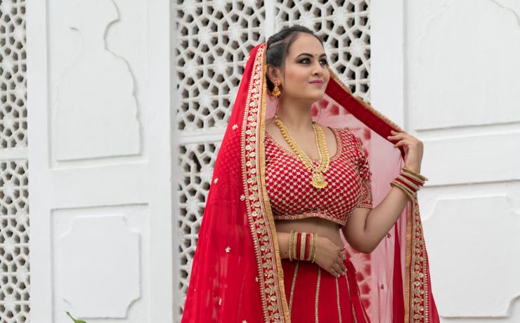 Indian bride in a red lehenga with gold jewellery