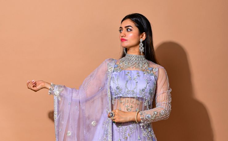 Young woman in a lilac color full embellished dress with diamond necklace and earrings